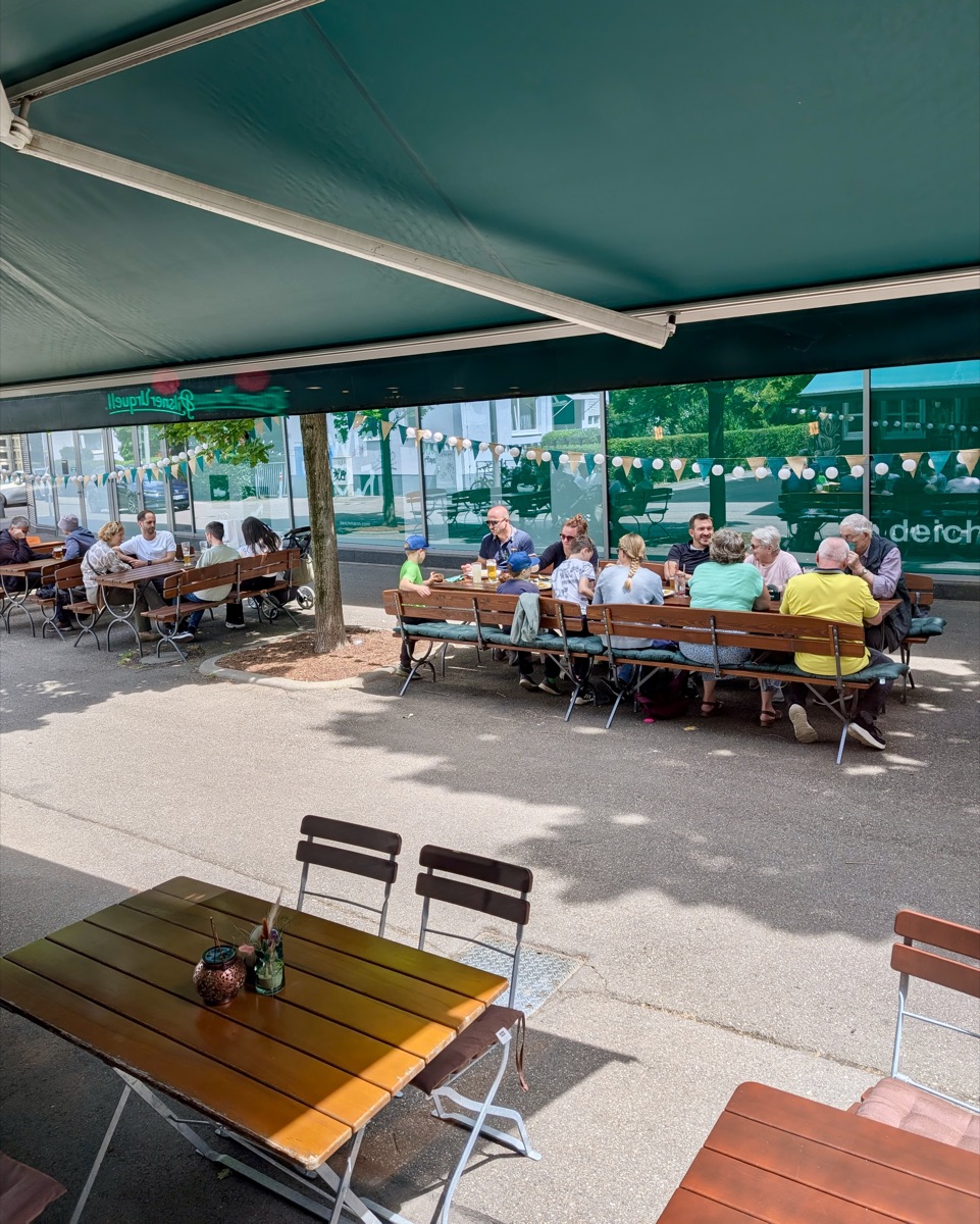 Gäste im Biergarten der Knödelstube unter der Markise bei böhmischem Bier